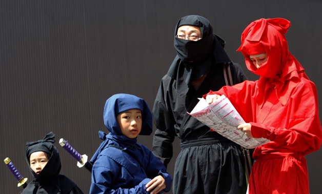 FILE PHOTO: Children dressed as ninjas pose for a souvenir picture during a ninja festival in Iga, about 450 km (280 miles) from Tokyo, April 6, 2008. REUTERS/Kim Kyung-Hoon/File Photo
