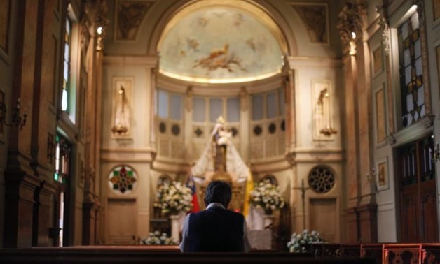 A Roman Catholic faithful prays during Mass at Santiago Cathedral in Santiago, February 16, 2013. REUTERS/Ivan Alvarado

