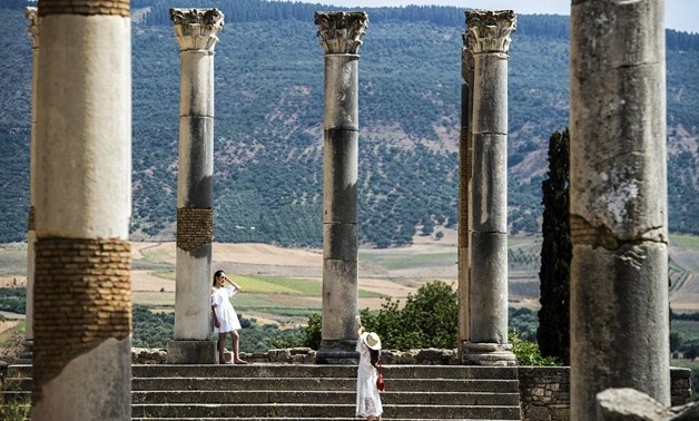 Tourists walk through the ruins of Morocco's oldest Roman site of Volubilis, in the center of a fertile plain at the foot of Mount Zerhounn, on July 25, 2018. Fadel Senna/AFP
