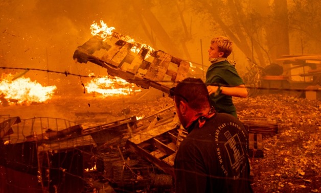 Alex Schenck, 15, throws flaming pallets while fighting to save his home as the Ranch Fire threatens the town of Clearlake Oaks in northern California
