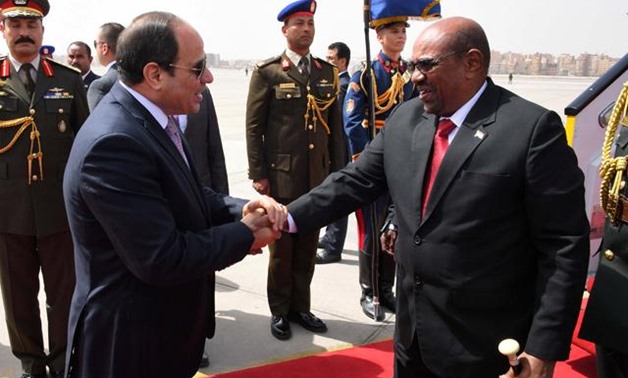 Egyptian President Abdel Fattah Al Sisi shakes hands with Sudan’s President Omar Al Bashir at Cairo’s airport, Egypt, on Monday (Reuters photo)