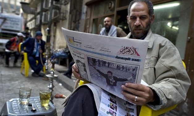 A man reads Egypt’s state-owned Al-Ahram during the January 25 revolution. Credit: AFP
