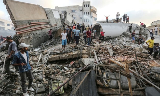People inspect the rubble of a building after an Israeli air strike on Gaza City, which Palestinians say housed a cultural centre while the Israeli army says it was used by the Islamist Hamas group
