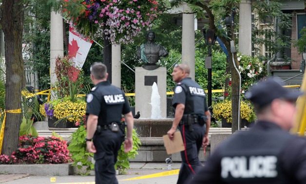 File - Police officers walk past Alexander the Great Parkette while investigating a mass shooting on Danforth Avenue in Toronto, Canada, July 23, 2018. REUTERS/Chris Helgren