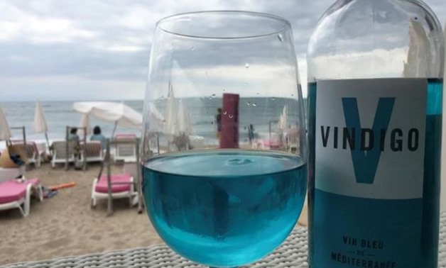 A glass of Vindigo, Mediterranean chardonnay wine, is seen at a beachfront restaurant in Sete, France, August 9, 2018. The wine is filtered through a pulp of red grape skins which contain a natural pigment, anthocyanin, and gives the wine its blue colour.