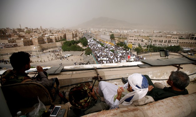 Houthi fighters watch from the roof of a building as they secure the site of a rally attended by supporters to mark the anniversary of launching their motto (Sarkha), in which they call for the "Death of America and Israel", in Sanaa, Yemen July 13, 2018.