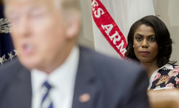 President Donald Trump (L) has now branded Omarosa Manigault Newman (R, in focus) a "dog" as their spat over her dismissal and recording of conversations in the White House escalated
