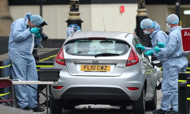 Police forensics officers work around a silver Ford Fiesta car that was driven into a barrier at the Houses of Parliament in London.
