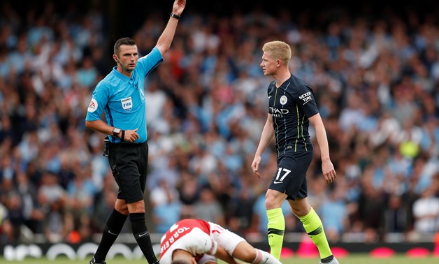 Football - Premier League - Arsenal v Manchester City - Emirates Stadium, London, Britain - August 12, 2018 Manchester City’s Kevin De Bruyne is booked by referee Michael Oliver as Arsenal's Lucas Torreira lies injured Action Images via Reuters/John Sible
