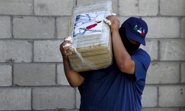 FILE PHOTO: An agent of the office of the Attorney General of Mexico carries a package of seized marijuana at the site of a passageway Mexican authorities on Thursday attributed to the cartel of fugitive kingpin Joaquin "El Chapo" Guzman in Tijuana, Octob
