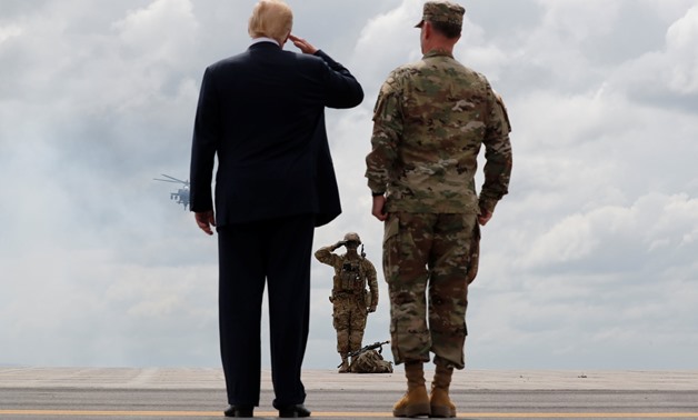 U.S. President Donald Trump salutes a U.S. Army soldier as he observes a military demonstration with U.S. Army Major General Walter “Walt” Piatt, the Commanding General of the Army's 10th Mountain Division at Fort Drum, New York, U.S., August 13, 2018. RE
