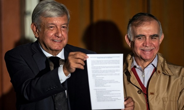 President-elect Andres Manuel Lopez Obrador shows a technical report on Mexico City's controversial new airport - already under construction - as he announces a referendum on whether to proceed with the project or cancel it
