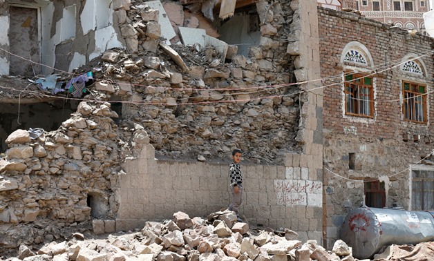 A boy stands next to a house destroyed by an air strike in the old quarter of Sanaa, Yemen August 8, 2018. Picture taken August 8, 2018. REUTERS/Khaled Abdullah
