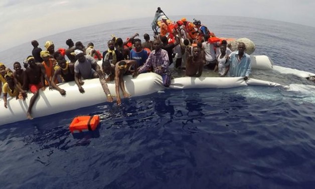 FILE PHOTO: Migrants on a dinghy are rescued by "Save the Children" NGO crew from the ship Vos Hestia in the Mediterranean sea off Libya coast, June 17 - Reuters