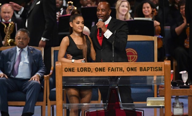 After her performance, Ariana Grande was congratulated by Bishop Charles H. Ellis III, who placed his arm high above her waist with his fingers pressed against her chest.