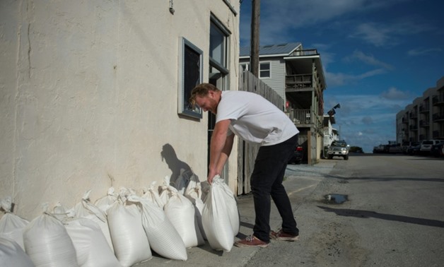 A man prepares sandbags outside a shop in Wrightsville Beach, North Carolina, ahead of the arrival of Hurricane Florence
