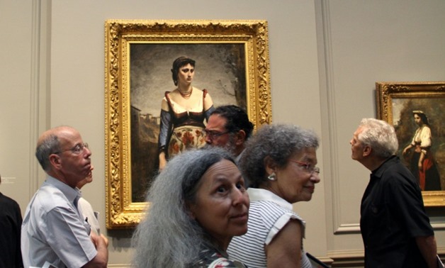 Visitors look at Jean-Baptiste-Camille Corot's "Agostina" (1866) at the National Gallery of Art in Washington on September 5, 2018-AFP / Olivia HAMPTON

