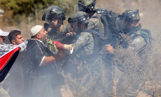 Palestinians scuffle with Israeli troops during a protest against Israeli land seizures for Jewish settlements, in the village of Ras Karkar, near Ramallah in the occupied West Bank September 14, 2018. REUTERS/Mohamad Torokman