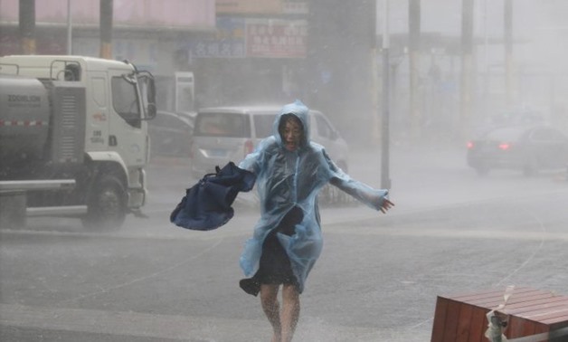 A woman runs in the rainstorm as Typhoon Mangkhut approaches, in Shenzhen, China September 16, 2018. REUTERS/Jason Lee
