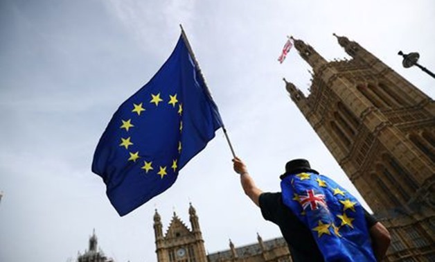 FILE PHOTO: An anti-Brexit demonstrator waves flags outside the Houses of Parliament, in London, Britain, September 10, 2018. REUTERS/Hannah McKay
