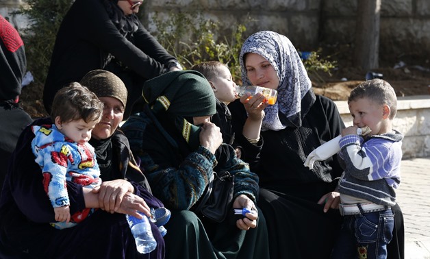 Syria women and children wait to get a visa stamp to enter Lebanon. Credit: Jamal Saidi/ Reuters
