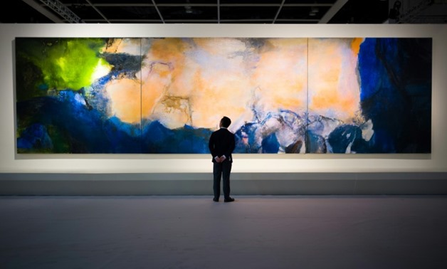 A man poses in front of 'Juin-Octobre 1985' by Chinese painter Zao Wou-Ki at Sothebys auction house showroom in Hong Kong on September 26.