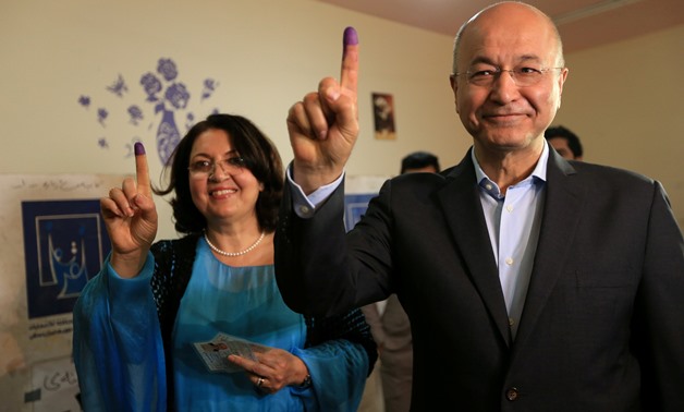 FILE PHOTO: Barham Salih, Former Prime Minister of Iraq's Kurdistan Regional Government and Head of the Coalition for Democracy and Justice with his wife show their ink-stained fingers after casting their votes at a polling station during the parliamentar