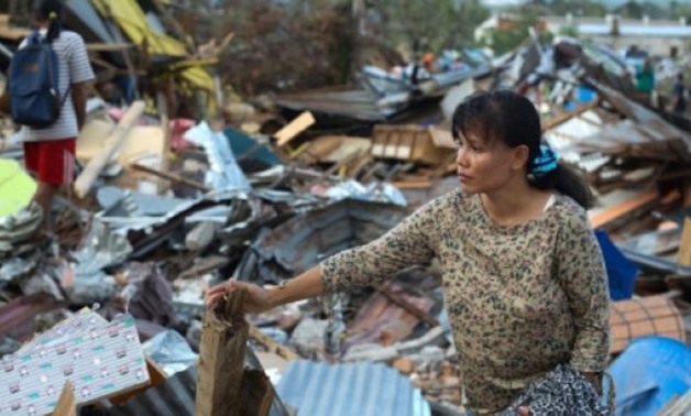 © AFP | Nonlis Kando stands amid the ruins on her home in Petobo, Indonesia