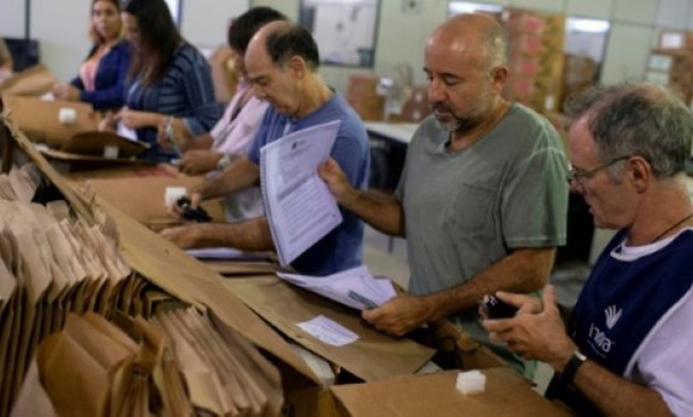 © AFP | Brazilian election authorities prepare electronic ballots in Rio de Janeiro on the eve of Sunday's vote