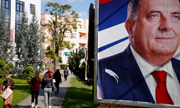 FILE PHOTO: People pass an election poster of Bosnian Serb nationalist leader Milorad Dodik in Banja Luka, Bosnia, September 26, 2018. REUTERS/Dado Ruvic/File Photo
