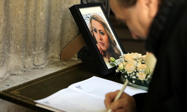 A man writes in the condolence book next to the picture of killed Bulgarian journalist Viktoria Marinova before her funeral service in Holy Trinity Cathedral in Ruse, Bulgaria, October 12, 2018. REUTERS/Stoyan Nenov
