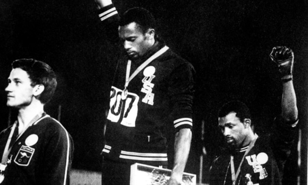 US athletes Tommie Smith (C) and John Carlos (R) raise their gloved fists in the Black Power salute against racism during their national anthem, after receiving their first and third place medals in the men's 200m event at the 1968 Mexico Olympics
EPU/AF