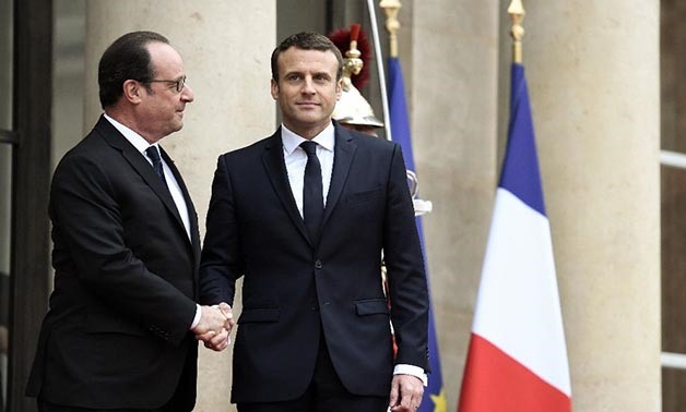 France's newly elected president Emmanuel Macron (R) is welcomed by his predecessor Francois Hollande - AFP