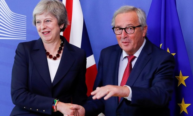 British Prime Minister Theresa May is welcomed by European Commission President Jean-Claude Juncker ahead of the European Union leaders summ - Reuters