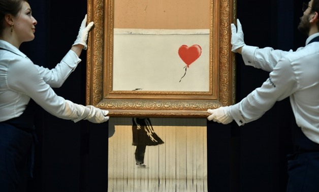 British street artist Banksy created an art world sensation by sending his painting through a shredder hidden in a frame moments after it sold at auction for £1,042,000 ($1.4 million, 1.2 million euros).