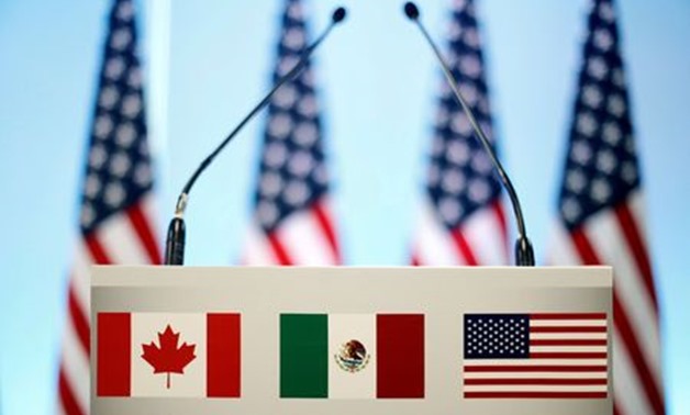 FILE PHOTO: The flags of Canada, Mexico and the U.S. are seen on a lectern before a joint news conference on the closing of the seventh round of NAFTA talks in Mexico City, Mexico, March 5, 2018. REUTERS/Edgard Garrido/File Photo
