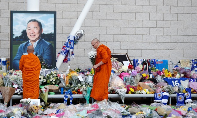 Soccer Football - Leicester City mourn and honour the victims of the helicopter crash - King Power Stadium, Leicester, Britain - October 31, 2018 Bhuddhist monks look at tributes after the club's owner Thai businessman Vichai Srivaddhanaprabha, and four o