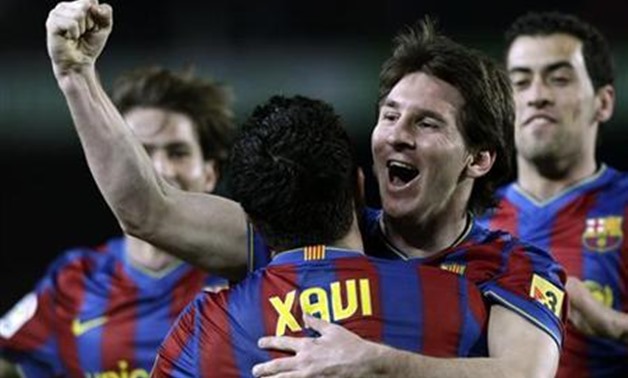  Barcelona's Xavi Hernandez (L) and Lionel Messi (R) celebrate a goal against Getafe during their Spanish league soccer match at Camp Nou stadium in Barcelona February 6, 2010. REUTERS/Albert Gea/Files