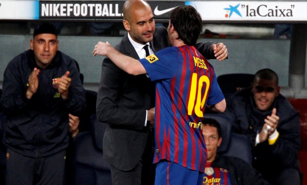 FILE PHOTO: Barcelona's Lionel Messi celebrates his fourth goal with coach Pep Guardiola against Espanyol during their Spanish first division soccer match at Nou Camp stadium in Barcelona May 5, 2012. REUTERS/Gustau Nacarino/File Photo
