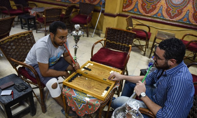 Unemployed Egyptian men play backgammon at a cafe in the capital Cairo on October 8, 2015. AFP PHOTO / MOHAMED EL-SHAHED