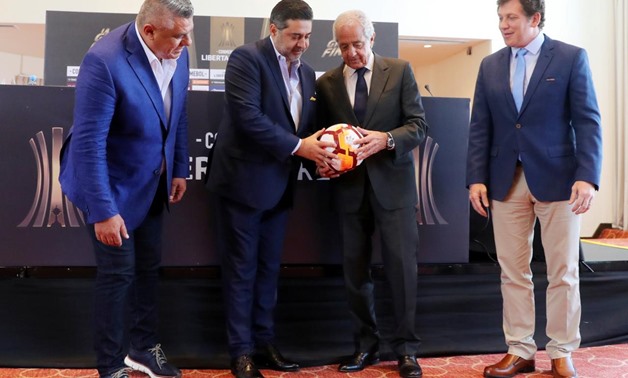 Boca Juniors' president Daniel Angelici (2nd L) and his counterpart of River Plate Rodolfo D'Onofrio hold a ball as Alejandro Dominguez (R), President of the South American Football Confederation (CONMEBOL) and Claudio Tapia, president of the Argentine Fo