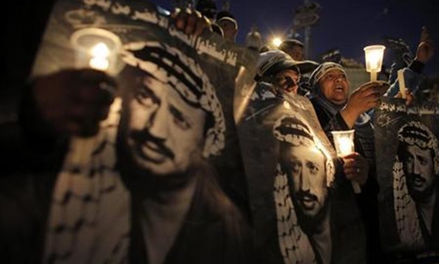 Palestinians hold candles and posters depicting late Palestinian leader Yasser Arafat during a rally marking the 9th anniversary of his death near Damascus Gate in Jerusalem's Old City November 11, 2013. REUTERS/Ammar Awad
