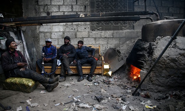 Abu Fahad (2nd R) rests with colleges inside a workshop in the rebel-held besieged Douma neighbourhood of Damascus, Syria April 1, 2017. REUTERS/Bassam Khabieh