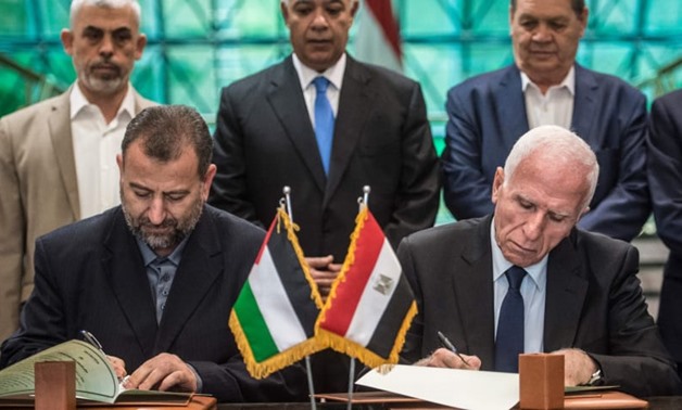Fatah's Azam al-Ahmad (R)and Saleh al-Arouri of Hamas sign a reconciliation deal at the Egyptian intelligence services headquarters in Cairo on October 12, 2017.KHALED DESOUKI/AFP