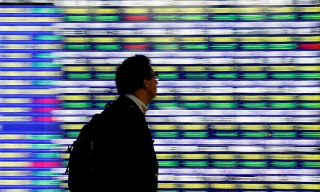 A man walks past an electronic stock quotation board outside a brokerage in Tokyo, Japan, November 13, 2018. REUTERS/Toru Hanai