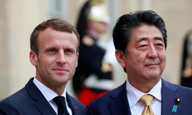 FILE PHOTO: French President Emmanuel Macron greets Japanese Prime Minister Shinzo Abe in the courtyard of the Elysee Palace in Paris, France, October 17, 2018. REUTERS/Gonzalo Fuentes
