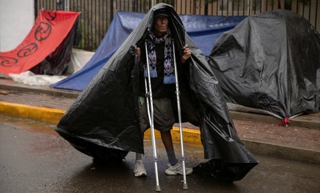 Rafael, 33, from Honduras, part of a caravan of thousands of migrants from Central America trying to reach the United States, covers himself with a plastic wrap at a temporary shelter during heavy rainfall in Tijuana, Mexico, November 29, 2018. REUTERS/Al
