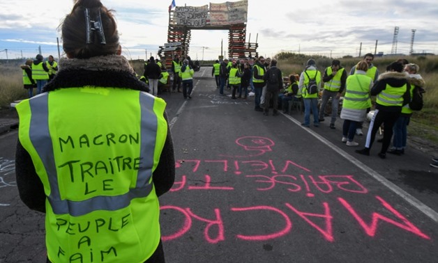 Yellow vest protesters have blocked fuel depots like this one in Frontignan, southern France, where a woman's vest reads "Macron, traitor, the people are hungry"
