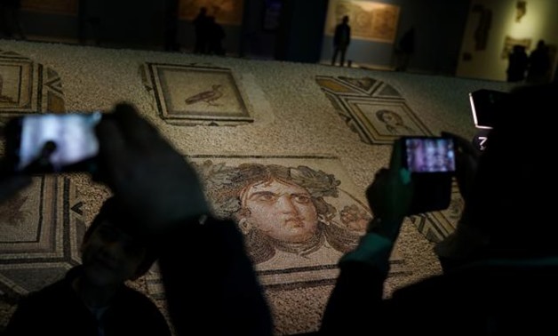 Visitors take pictures of the missing pieces of the historic "Gypsy Girl" mosaic on display in an exhibition at their origin in Gaziantep, Turkey, December 8, 2018. REUTERS/Umit Bektas.