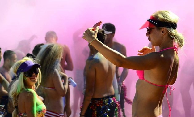 A tourists takes a selfie during a color festival in Sharm el-sheikh